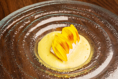 Butter-poached sable fish with cucumber, Quiet Acres summer corn, and sunflower petals at Revé