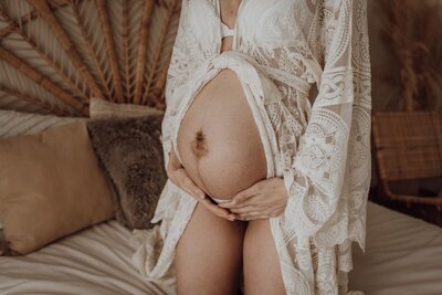 Detail van zwangere buik in kant tijdens zwangerschapsshoot oost-vlaanderen
