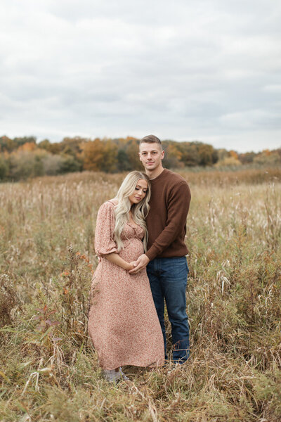 Expecting mother in father standing in Wisconsin field