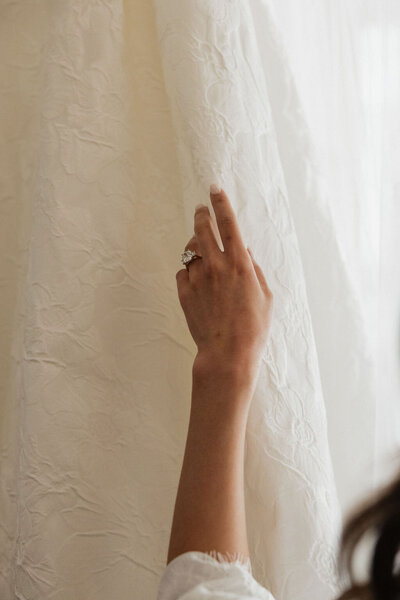 Candid getting ready photo of bride holding her dress at Calipaso Vineyard in Paso Robles, California