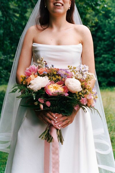 A bride holds flowers at Lareau Farm Inn in Waitsfield VT