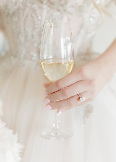 luxury bride holding a glass of champagne wearing a galia lahav wedding gown