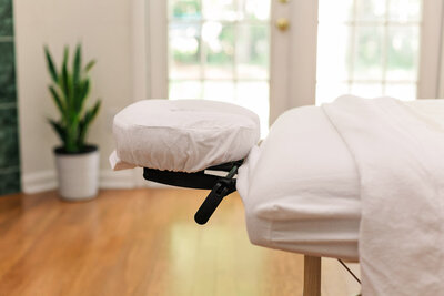 Massage table set up in a living room next to patio doors