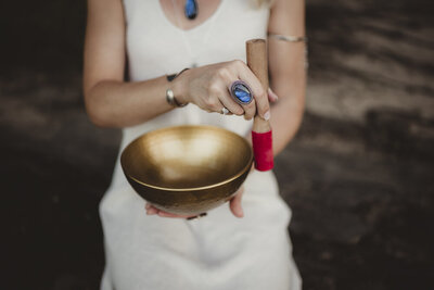 Energy healer Caroline Weiss using a singing bowl to support meditation, sound healing, and emotional balance.