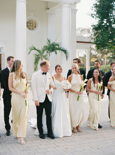 Classic Palm Beach wedding at The Lost Tree Club featuring a bridal party dressed in elegant white and pale yellow tones.