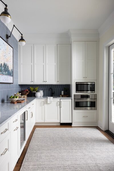 Neutral transitional kitchen with waterfall marble island and white cabinets designed by SC interior designer Haven + Harbor
