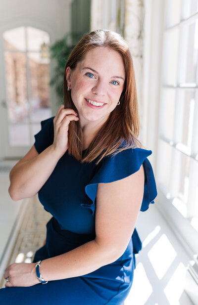 Colorado wedding photographer headshot with photographer smiling while wearing a navy blue top and smiling at the camera