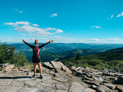 Libby Stenzel celebrates after reaching the peak of a mountain. 