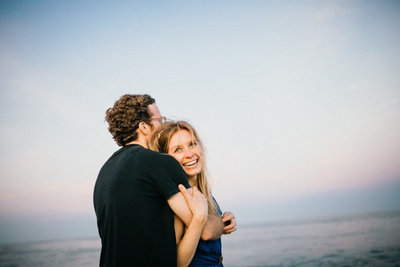 Engaged couple spend their engagement session having fun on the beach in New York.