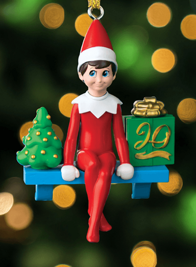 20th Anniversary Scout Elf ornament over a Christmas Tree background