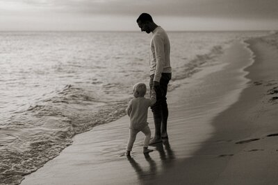 Father and child walking the shore captured by a photographer in Traverse City

