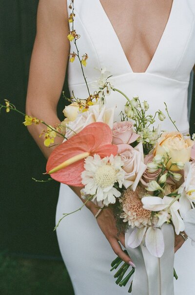 Bride holding a modern romantic pastel bouquet with garden roses and airy blooms, styled by Melissa Alison Events.
