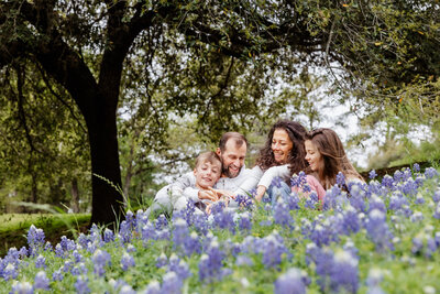 A family picture in a bluebonnet field