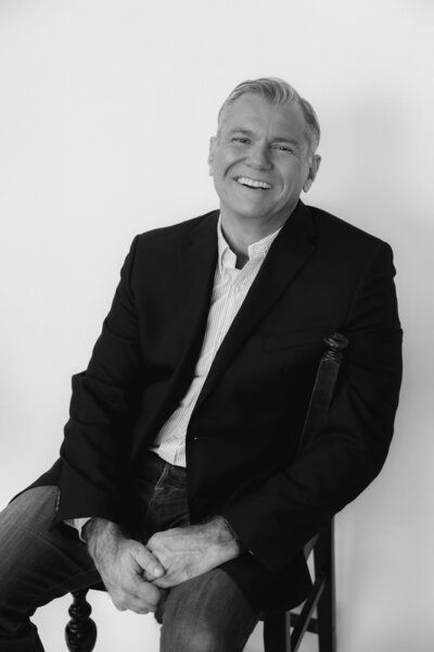 Man sitting in chair taking photos for LinkedIn profile picture