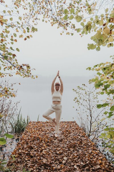 Isabell macht eine Yoga Pose auf einem Steg am See