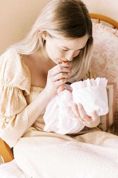 mom kissing baby's hand in in-home peoria, illinois newborn photos 