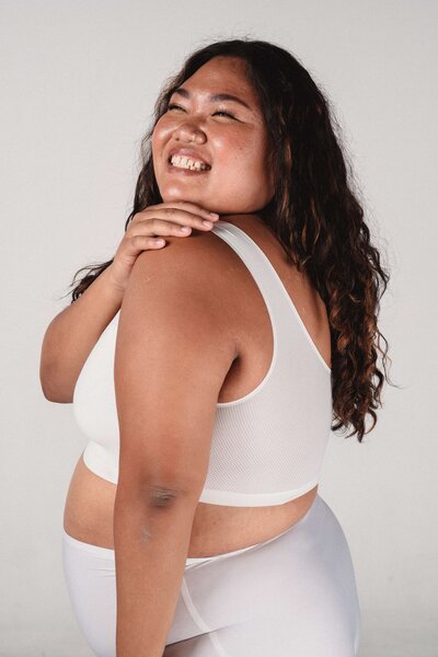 Woman in white smiling looking over shoulder