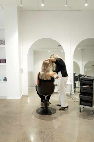 Hair dresser working in bright salon