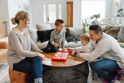 Family of four playing a board game at home together