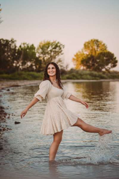 girl in white dress bare feet playing in shallow river