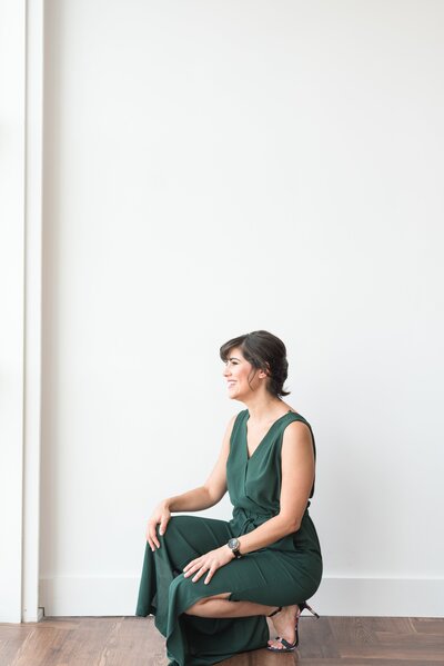 Headshot at 14Tenn in Nashville of a woman kneeling in a green jumpsuit