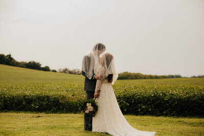 bride and groom portraits in a field