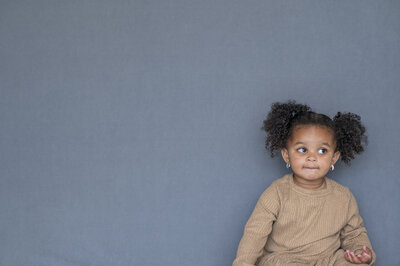 Little girl with her hair in two pony tails,  waiting for her photo to be taken