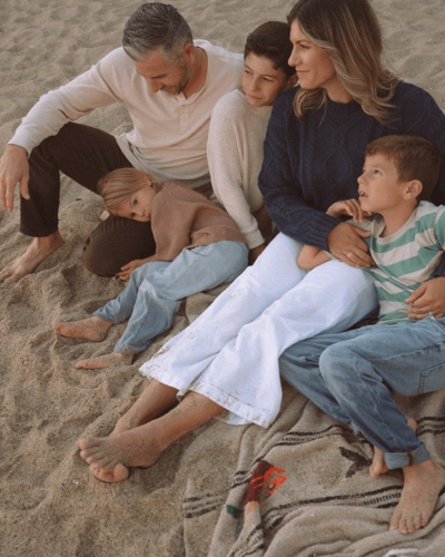 family of five snuggled on beach blanket at laguna beach