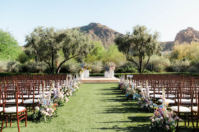 Outdoor ceremony setup at El Chorro wedding venue with floral aisle arrangements and Camelback Mountain views.