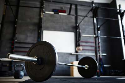 Eine Hantel in einem Fitnessstudio vor einer Wand mit Reckstangen
