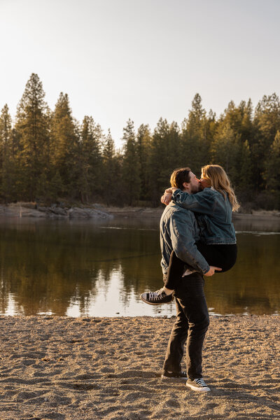 idaho engagement photography of a man lifting his fiance in a gold field