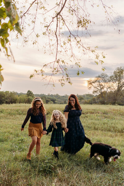 family walking with dog during photos in Franklin tennessee