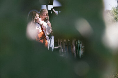 Family and newborn baby photographed through a cactus on their front porch in San Diego, CA.