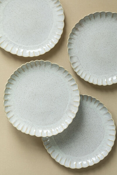 Siren dishes, featuring scalloped edges and a sand-beige glaze finish