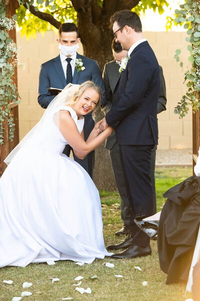 A bride laughing as her and her groom say their vows.