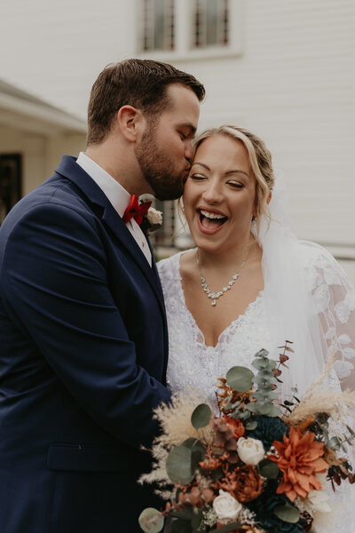 groom kissing bride on forehead