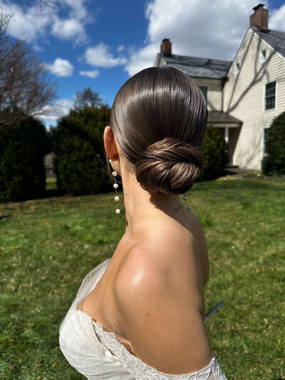 Bride with a sleek low bun and clean finish — polished, luxury bridal hair by Klover Beauty for a formal Maryland wedding.