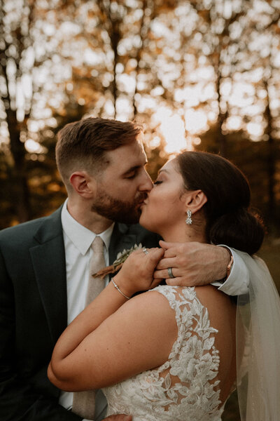 groom and bride kiss in MA autumn