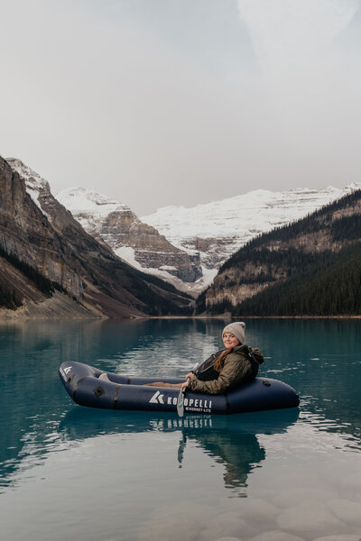 Montana Wedding Photographer poses in a packraft while paddling around in an alpine lake.