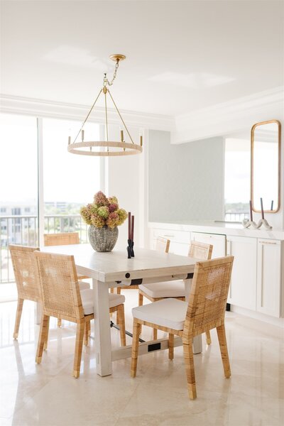 Dining room table with wooden chairs and floral bouquet accent