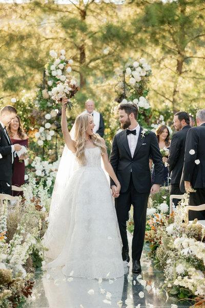 groom and blonde bride in white wedding dress and pink flowers