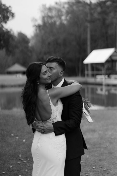 Groom kissing his bride wedding portrait