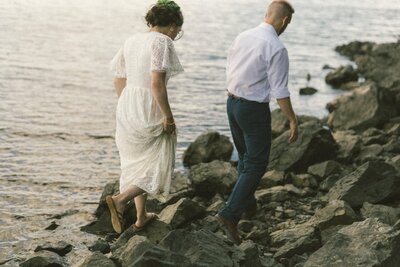 bride and groom wander along the sea shore