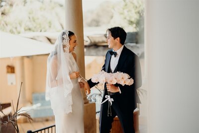 A couple share a joyful first look at Iron Gate Estate before their Tuscan-style elopement, with orchids and a lace-edged veil.