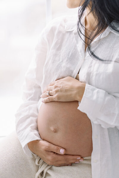 Richmond Maternity Photographer | Photo of a pregnant mother in a white button up shirt, holding her belly by Jacqueline Aimee Portraits