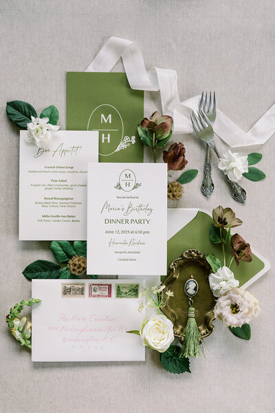 Custom event branding flat lay including a custom modern crest, personalized menus and matching place cards