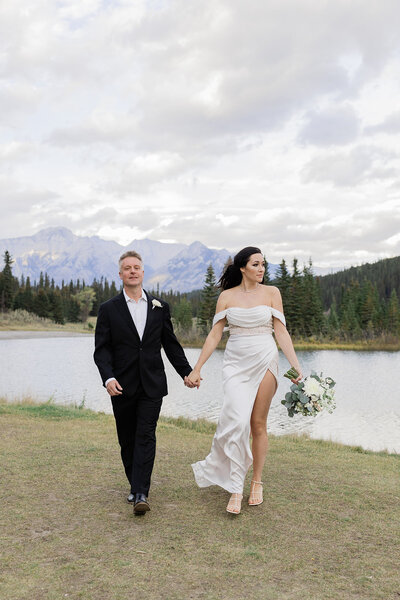Elopement couple walking in front of mountains after their wedding