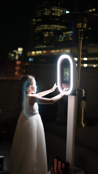 A kid using the kid friendly Dallas Fort WOrth Photo Booth at a roof top wedding.