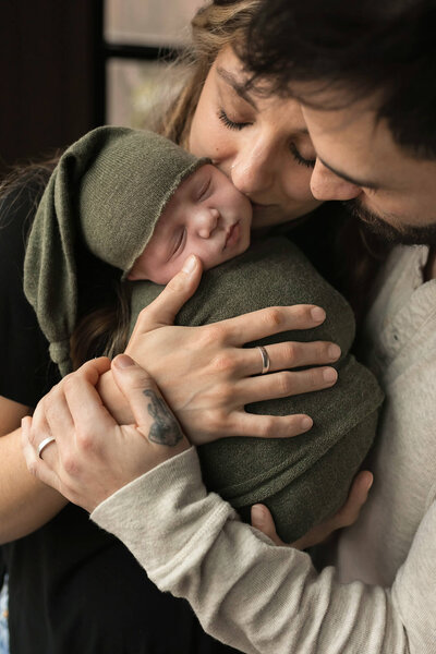 NJ Baby photos of mom and dad snuggling baby