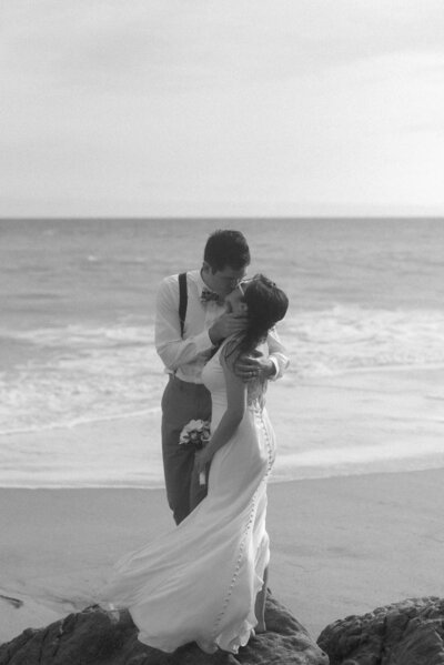 Romantic beachside kiss between newlyweds, showcasing a dreamy and natural side of Seattle wedding photography.